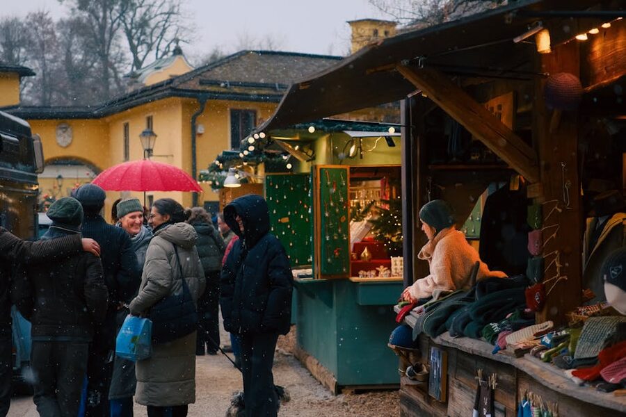 Wooden Christmas market stall with snow on the roof, lit lanterns, and traditional Swedish wares laid out