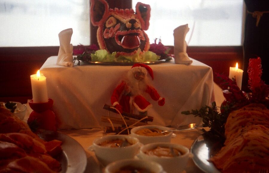 Traditional Swedish julbord laid out with pickled herring, ham, meatballs, salmon, and crispbread on a long table