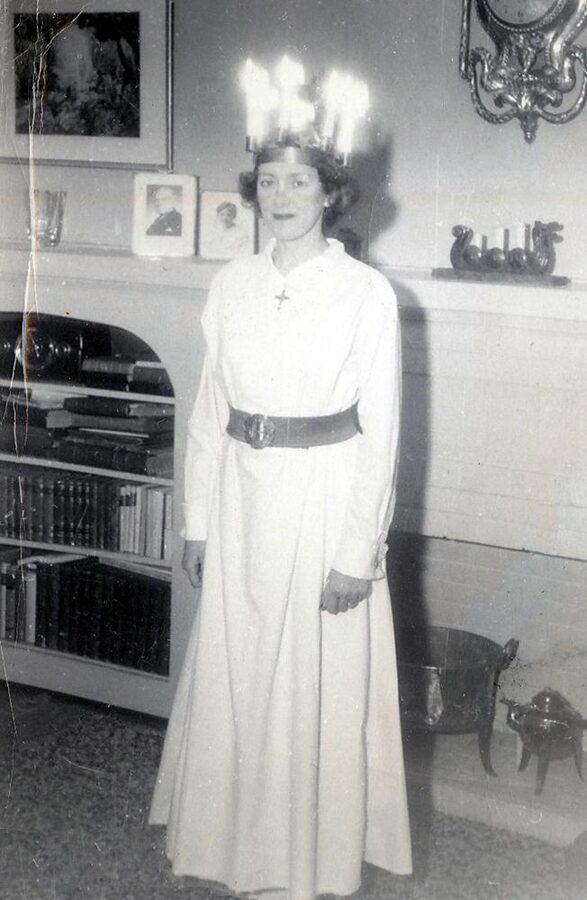 Black-and-white historical photograph of a young woman in a white robe wearing a candle crown for Lucia Day in 1951