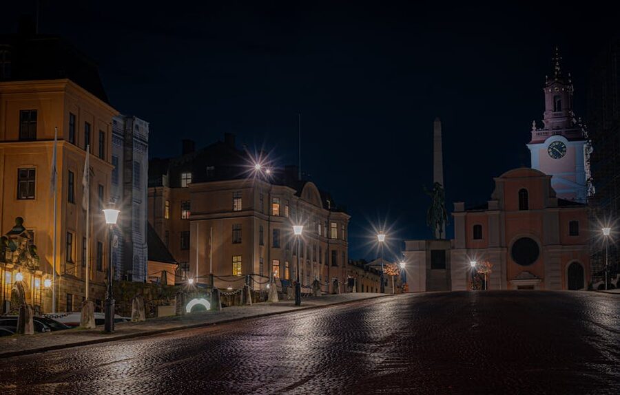 Stockholm street at night with snow falling and warm lit windows of historic buildings