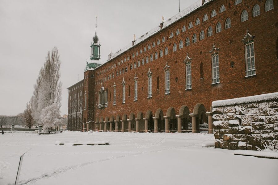 Stockholm waterfront with snow on the buildings, ice forming on the water, and low winter sun