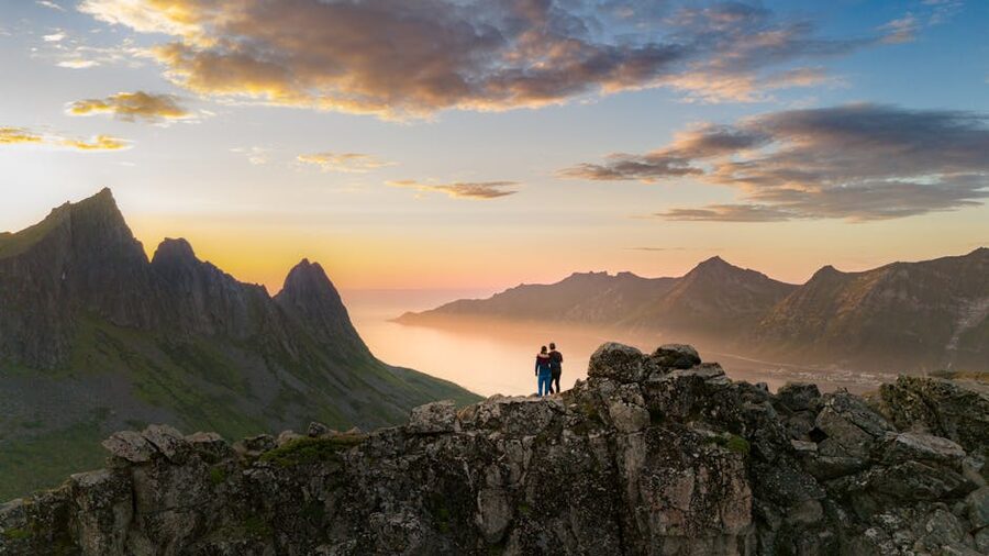 Couple watching the sunset over the mountains of Senja in northern Norway