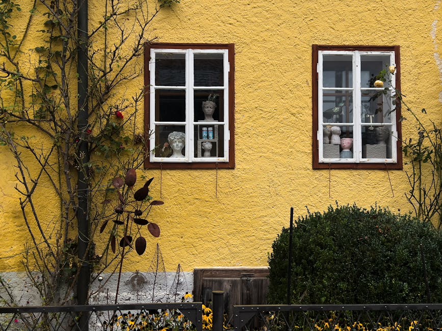 A Skagen yellow house with white-trimmed windows and floral display