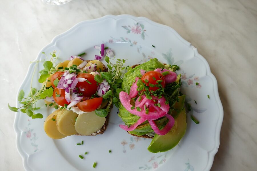 A classic smørrebrød platter with herring, beef tartare, egg and shrimp on dark rye in Copenhagen