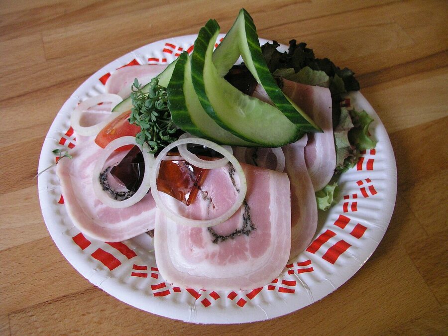 A traditionally laid-out plate of smørrebrød with herring and beef tartare