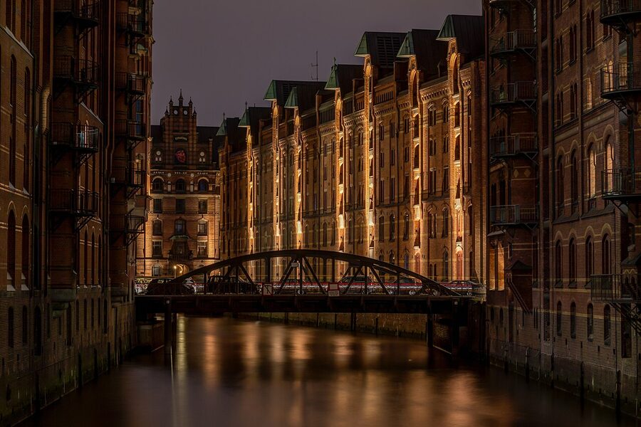 Speicherstadt Block P at dusk, illuminated red brick reflected in the canal