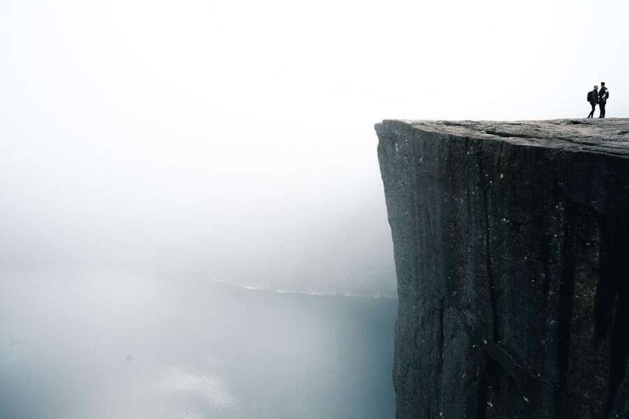 People at Preikestolen edge in fog above Lysefjord