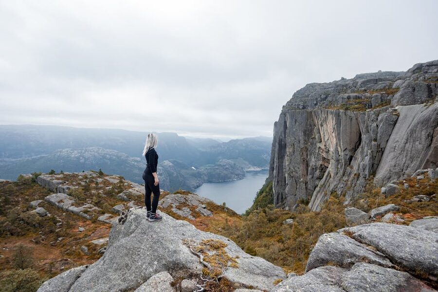 Hikers at the edge of Preikestolen above Lysefjord, Norway