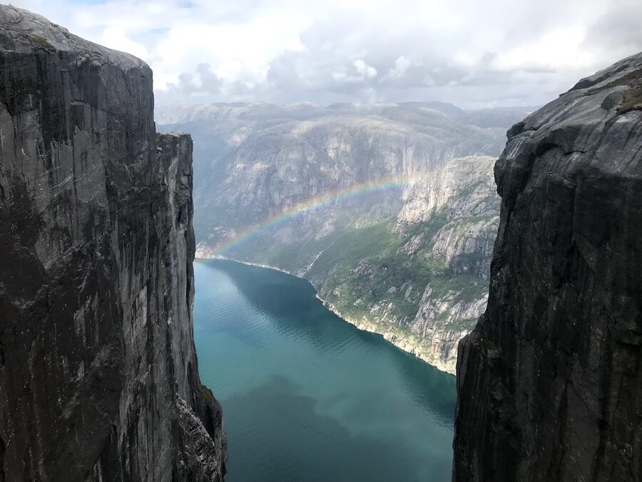 Kjeragbolten boulder wedged in a cliff with rainbow