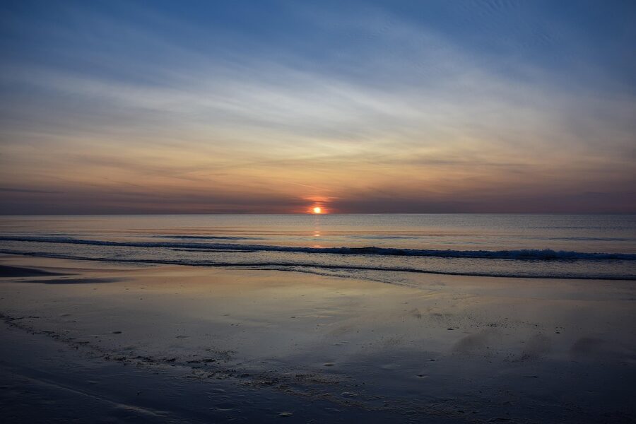 Sunset over a Skagen beach in late summer with golden light on the sand