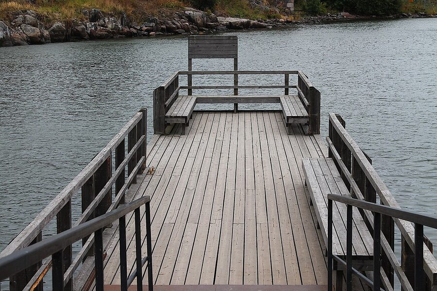 A bridge between Suomenlinna's islands with grass and stone fortifications under summer sky