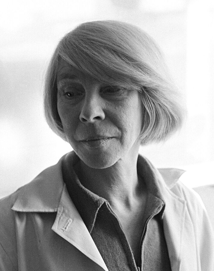 Black-and-white photograph of Tove Jansson at her summer cabin in 1969, working at a desk by a window