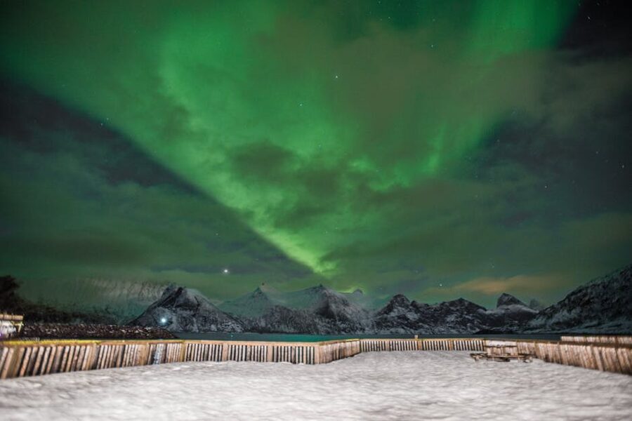 Aurora over snowy mountains in Tromso