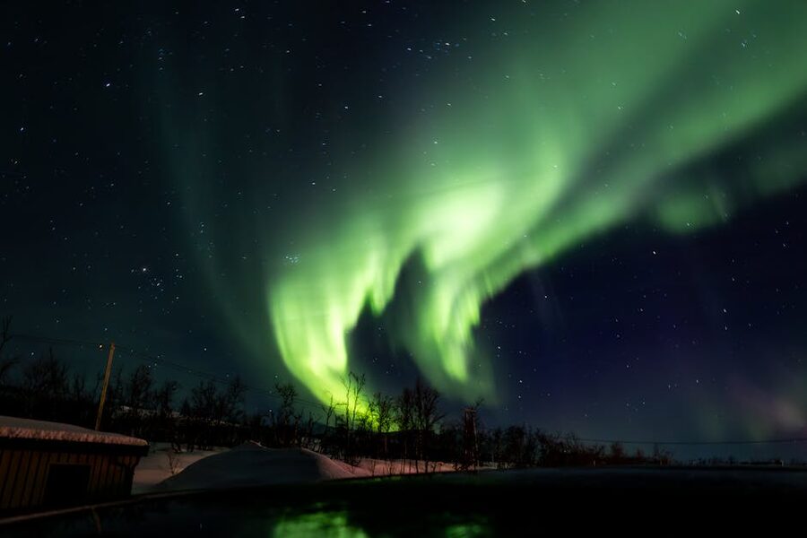 Aurora borealis over a snowy Tromso landscape