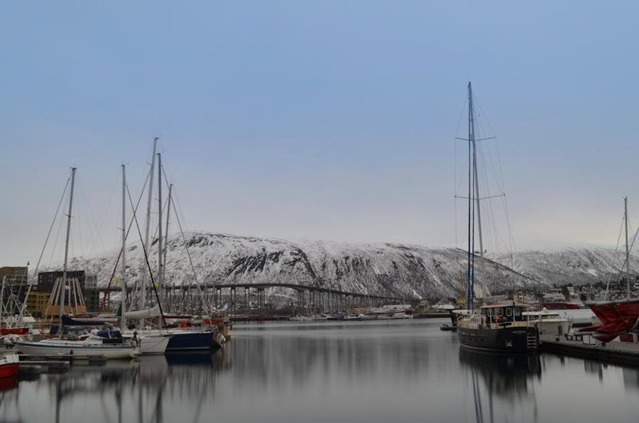 Tromso harbor in winter with snowy mountains