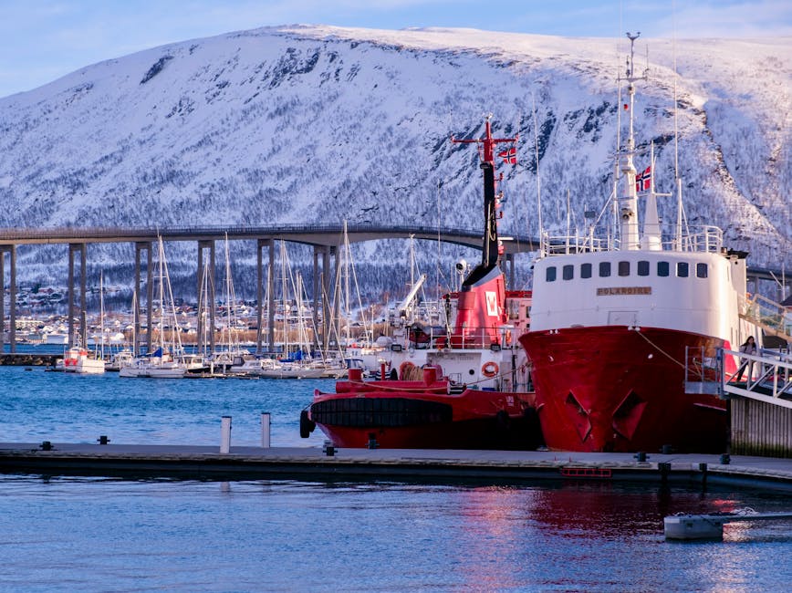 Red ships at Tromso harbor with snow-covered mountains