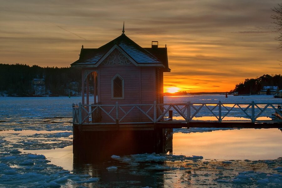 A wooden swimming hut and pier at Ruissalo in winter ice