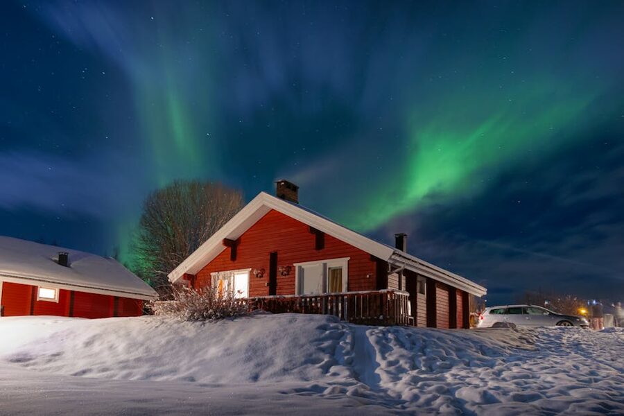 Red Finnish cottage under the aurora in Lapland